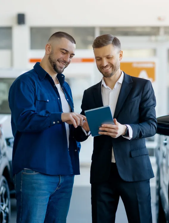 Image: man is signing rental contract at car dealership