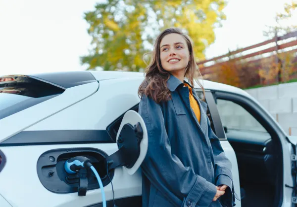 Woman waiting next to electric car
